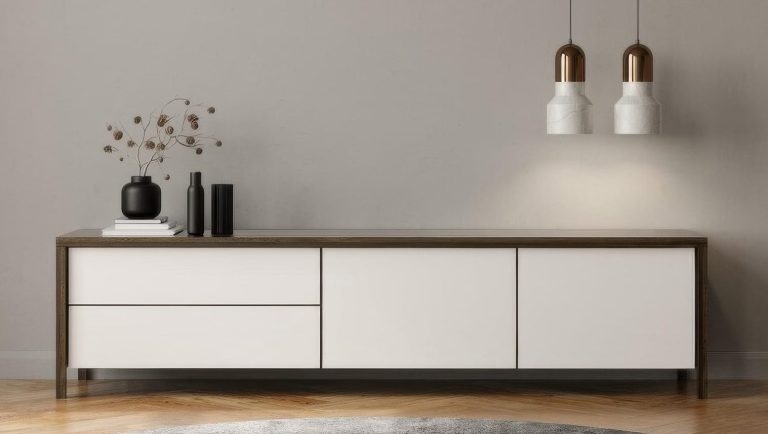 Mueble de madera con tiradores, dos lámparas colgantes y decoración minimalista.